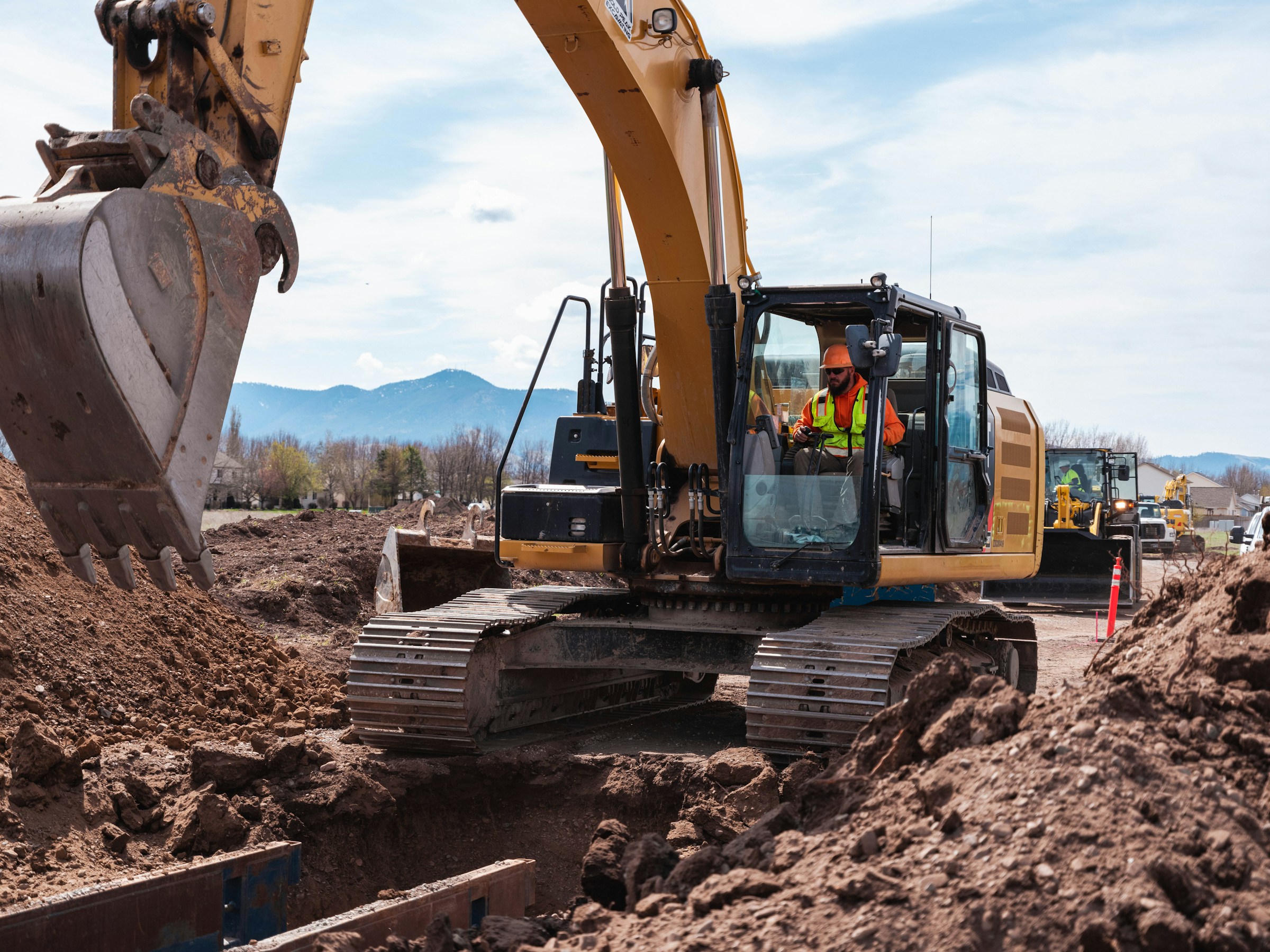 Excavator and crew working on a prepared construction site
